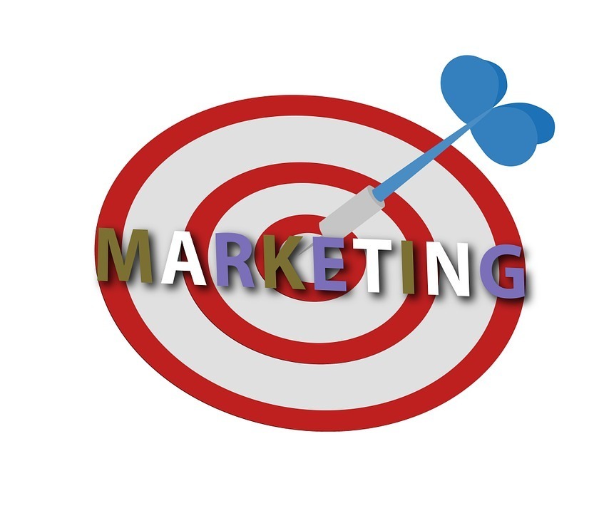 An illustration of a red and white target with a blue dart in the center. The word "MARKETING" is superimposed over the target in multicolored, uppercase letters, symbolizing direct marketing strategies for guaranteed success.